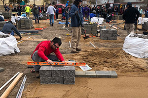 A Mississippi State Landscape Contracting and Management student in the Business Management Concentration gets hands-on experience in the field laying pavers on a prepared dirt foundation