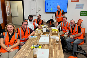 Wearing orange vests before a site visit, a group of Mississippi State Landscape Contracting and Management students in the Business Management Concentration meet around a wooden conference table